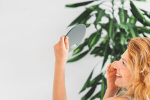 SIDE VIEW OF A WOMAN HOLDING A SMALL MIRROR HIGH U 2023 11 27 05 32 09 UTC 300X200 1